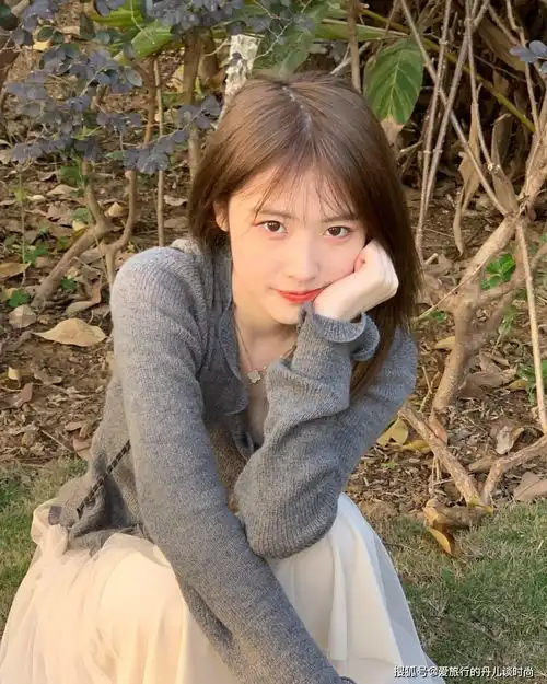  高颜值长发美女身穿灰色针织衫搭配白色半身裙,清新又甜美